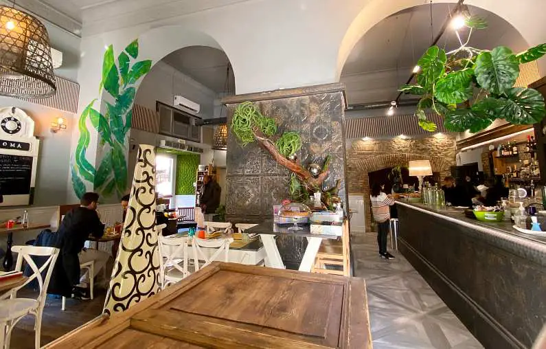 Inside Buddy Veg, a mediterranean looking restaurant with white walls, plants and grey panelling