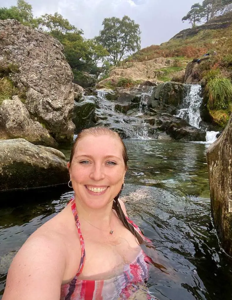 Mel taking a selfie swimming in the Watkin Path Waterfall pool wearing a red bikini