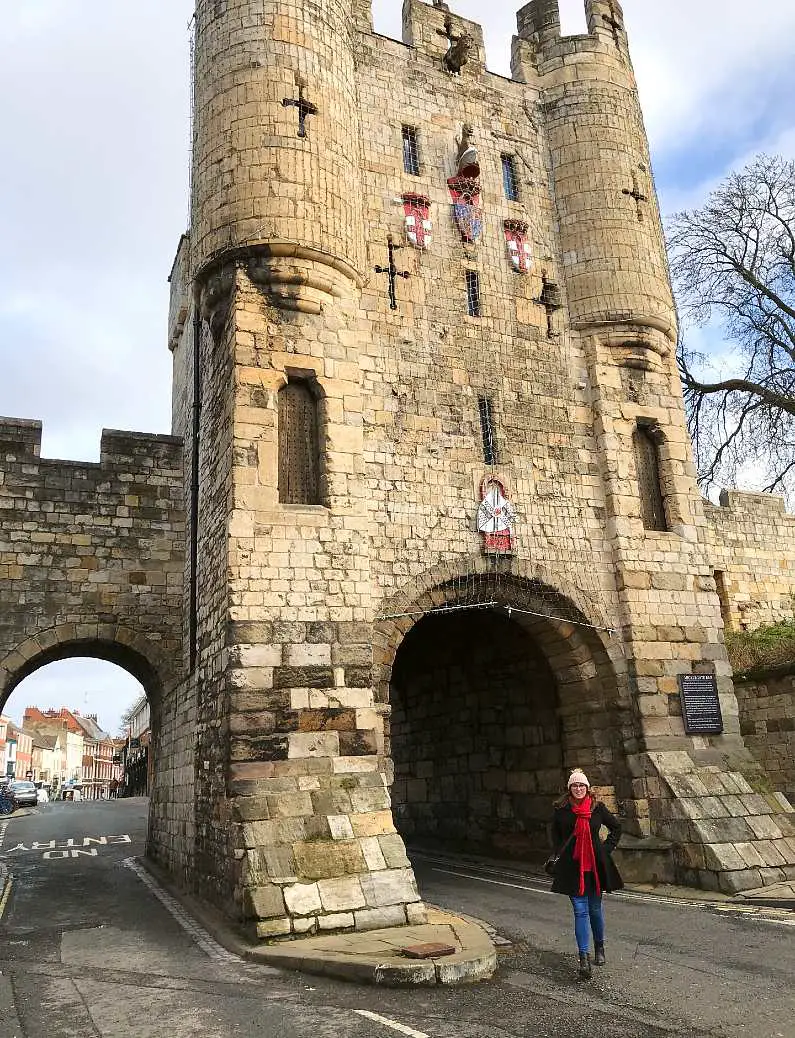 Mel walking under Micklegate in York a large medieval structure with arches for cars to pass