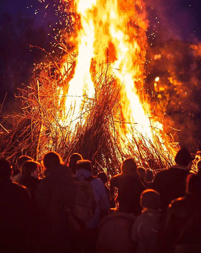Large bonfire with a crowd of people in front of it