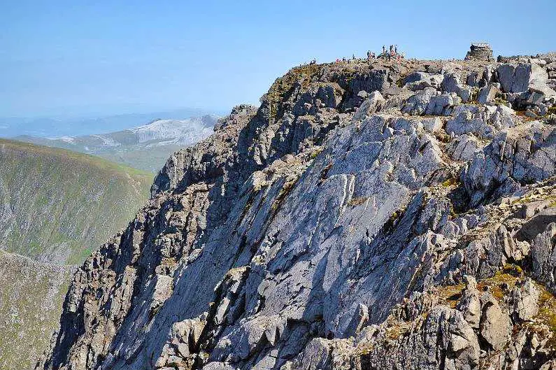The summit of Ben Nevis with people hiking on top in the distance